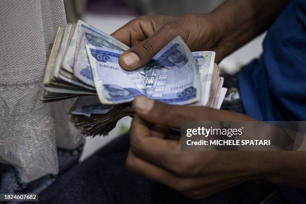 Shop owner counts Ethiopian Birr in his stall at the Shola Market in Addis Ababa on December 4, 2023.