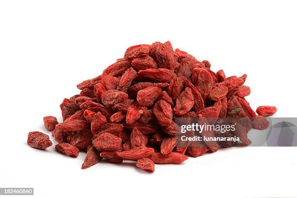 heaping pile of dried goji berries on white background - wolfberry stock pictures, royalty-free photos & images