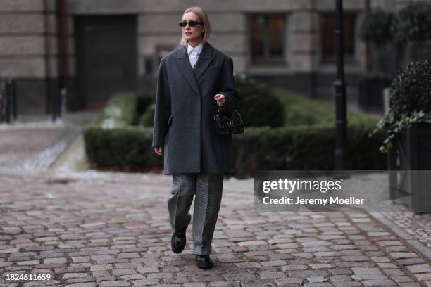 Marlies Pia Pfeifhofer seen wearing brown oval sunglasses, silver earrings, white cotton buttoned blouse / shirt, COS dark grey short oversized wool...