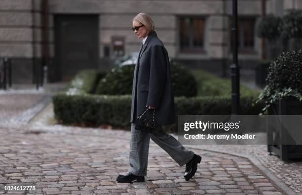 Marlies Pia Pfeifhofer seen wearing brown oval sunglasses, silver earrings, white cotton buttoned blouse / shirt, COS dark grey short oversized wool...