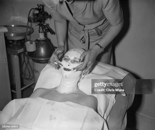 Beautician applying a facial mask to the face of a female client at Helena Rubinstein's London salon, April 1948.