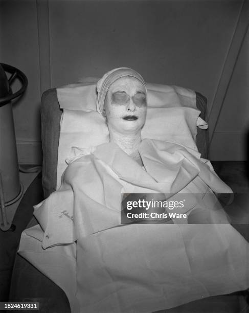 Female client wearing a face mask and eye pads during a beauty treatment at Helena Rubinstein's London salon, April 1948.