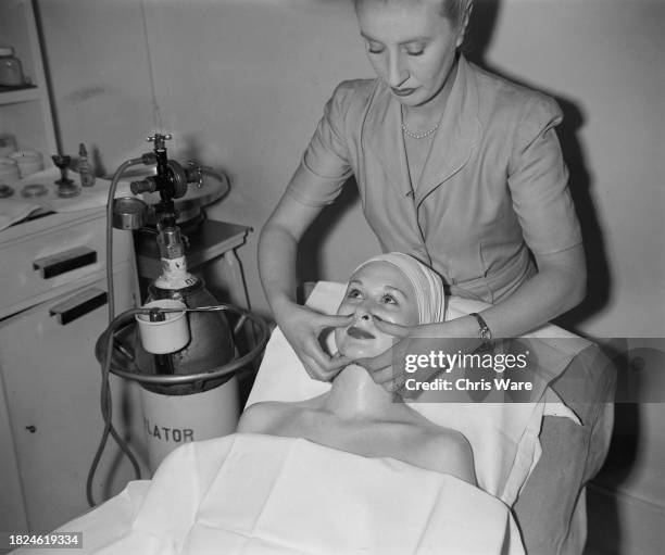 Beautician massaging a facial cream into a client's skin during a beauty treatment at Helena Rubinstein's London salon, April 1948.