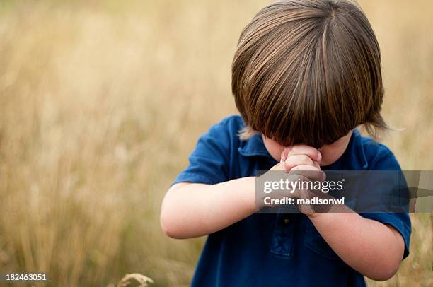 niño de oración - niños orando fotografías e imágenes de stock