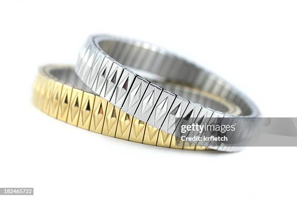 silber und goldene armbänder auf weiß - anhänger armband stock-fotos und bilder