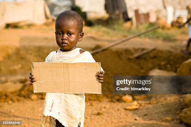 african boy holding a blank cardboard sign - 1 year poor african boy stock pictures, royalty-free photos & images
