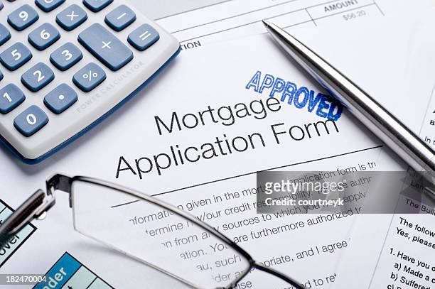 approved mortgage application form with a calculator and pen - mortgage document stock pictures, royalty-free photos & images