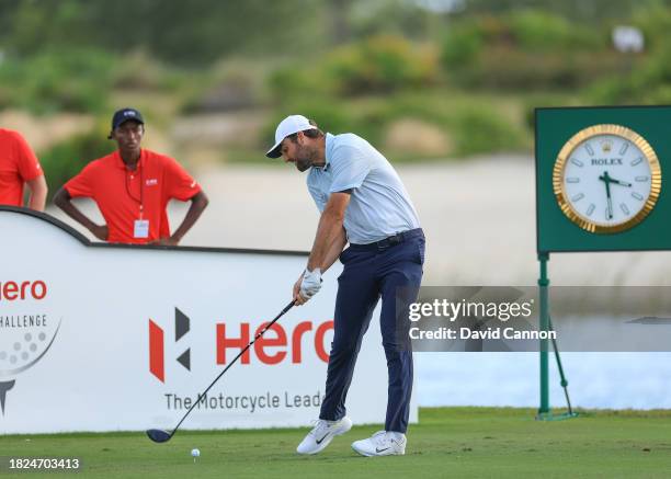 This image is part of a swing sequence; Scottie Scheffler of The United States plays his tee shot on the 18th hole during the first round of the Hero...