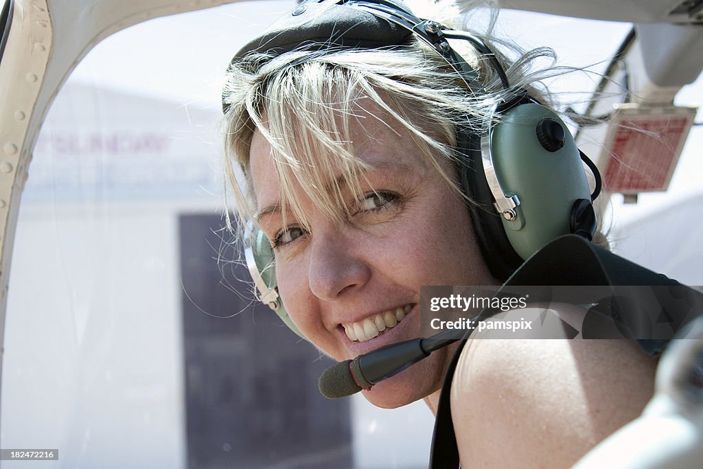 Adventurous Woman in Helicopter wearing headset