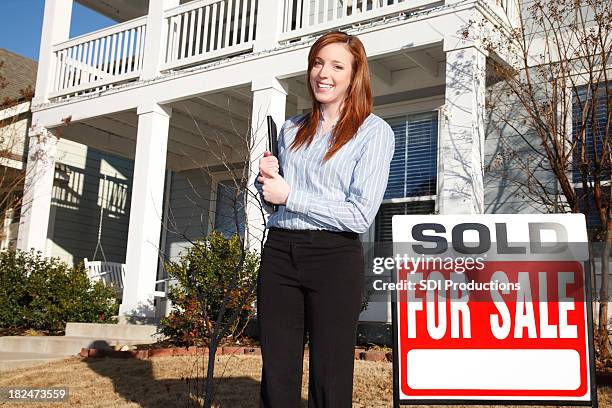 real estate agent in front of sold property - estate agent sign stockfoto's en -beelden