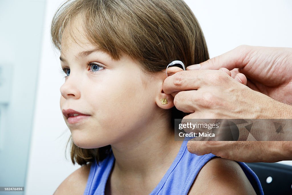 Doctor putting an earhorn in a child's ear