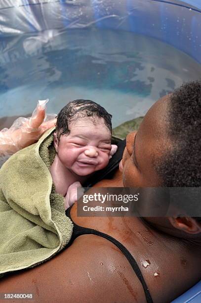 bebê dia a água nascimento; mãe e recém-nascido - home birth - fotografias e filmes do acervo