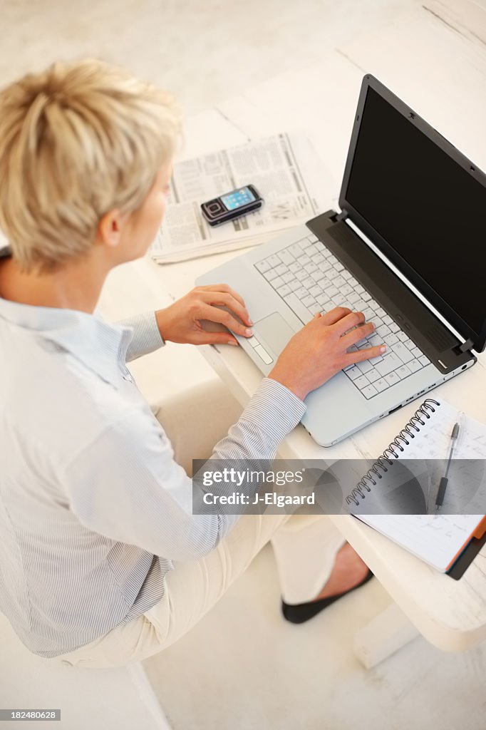 Haut vue d'une femme d'affaires travaillant sur un ordinateur portable