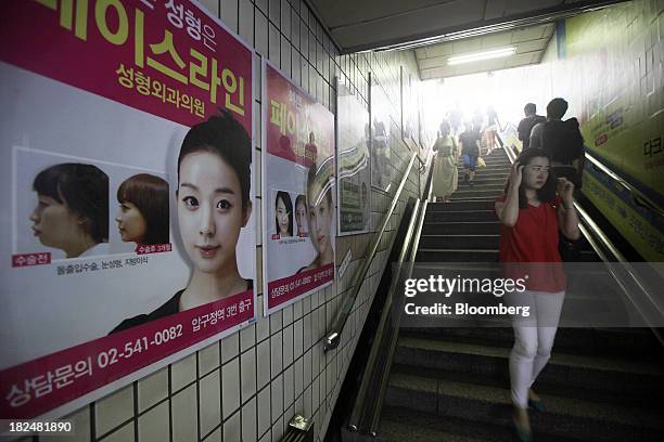 Plastic surgery advertisements are displayed along a staircase at the entrance of a subway station in the Apgujeong-dong area of Gangnam district in...