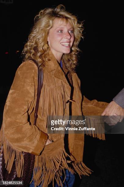 American actress Kate Capshaw, wearing a tan suede fringe jacket, attends the Beverly Hills premiere of 'The Three Amigos' held at the Academy...