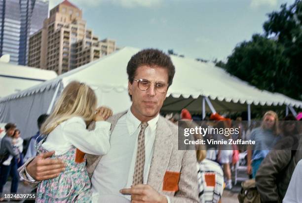 American actor Ted Danson carries his adopted daughter Alexis Danson at the 1990 Permanent Charities Committee of the Entertainment Industries'...