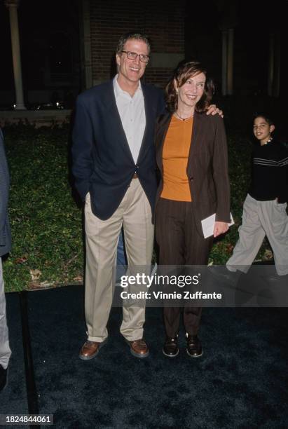 American actor Ted Danson, wearing a dark blue sports jacket over a white shirt and beige trousers, and his wife, American actress Mary Steenburgen,...