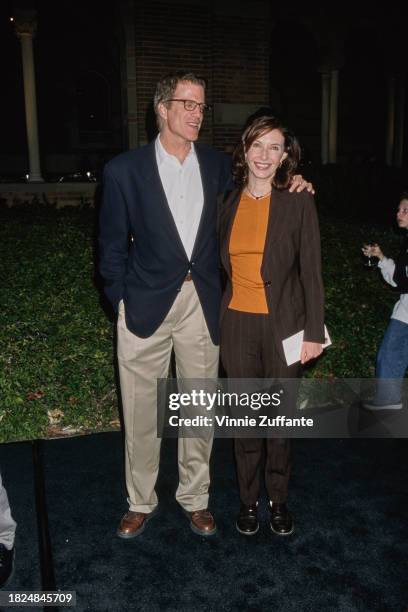 American actor Ted Danson, wearing a dark blue sports jacket over a white shirt and beige trousers, and his wife, American actress Mary Steenburgen,...