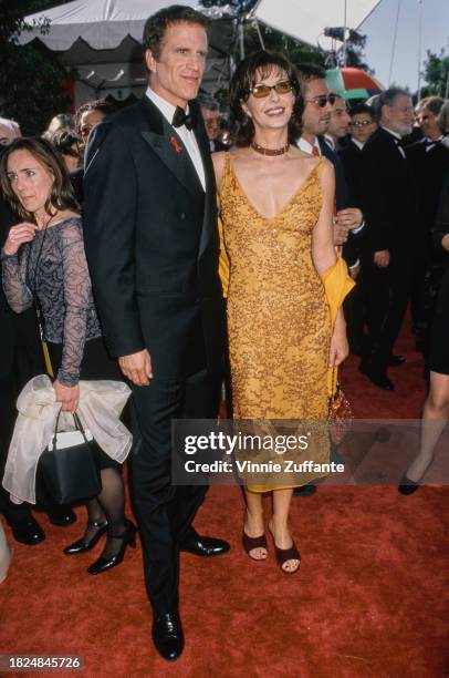 American actor Ted Danson, wearing a tuxedo and bow tie, and his wife, American actress Mary Steenburgen, who wears a yellow dress with gold thread...