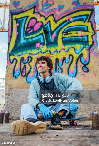 männlicher graffiti-künstler mit spraydosen - straßenmaler stock-fotos und bilder