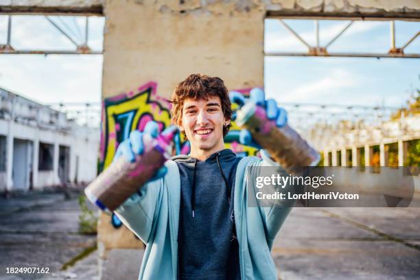 male graffiti artist with spray cans - grafitti artist stock pictures, royalty-free photos & images