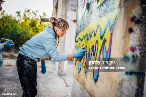 street artist painting colorful graffiti on wall - grafitti artist stock pictures, royalty-free photos & images