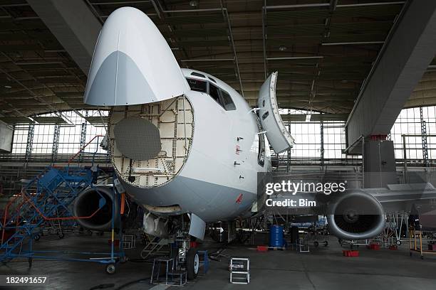 passagier-jet für wartung, reparatur und inspektion in hangar - flugzeugrumpf stock-fotos und bilder