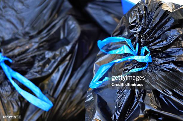 black garbage bags tied with blue strings - garbage bag stock pictures, royalty-free photos & images