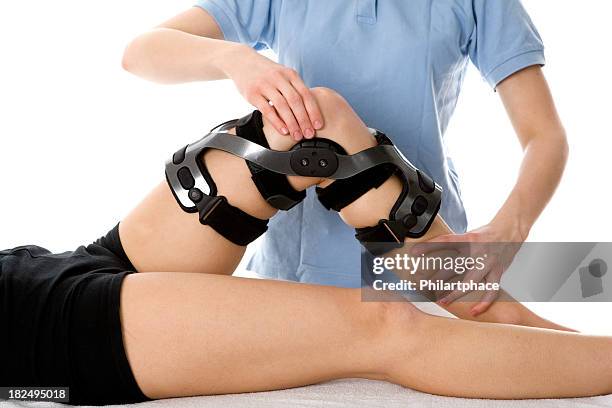 female doing physical therapy on her knee wearing brace - orthopaedic equipment stock pictures, royalty-free photos & images