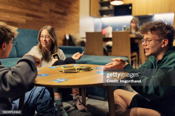 teenager spielen kartenspiel zu hause - kartenspiel tisch stock-fotos und bilder