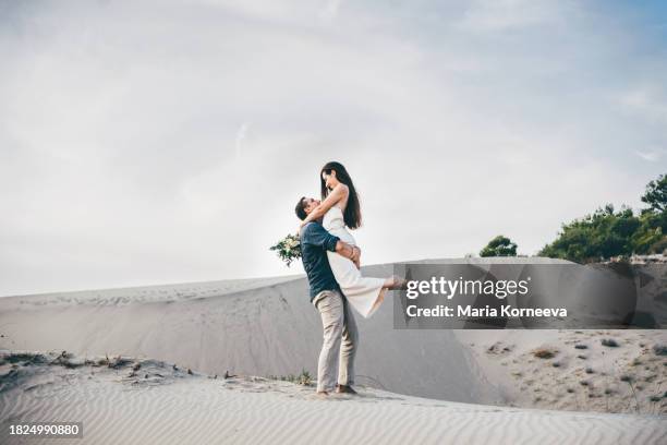 bride and groom walking holding hands in desert. - noivo papel em casamento imagens e fotografias de stock