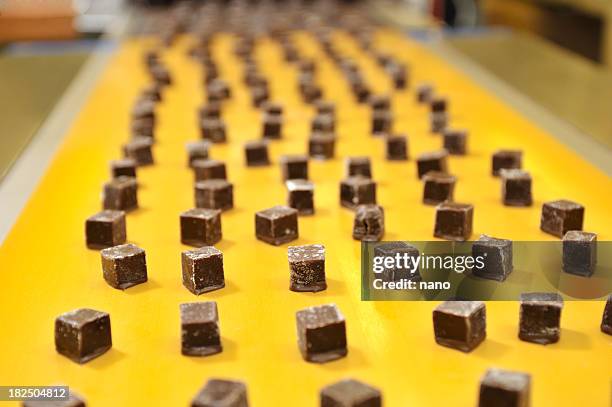 caramels on a conveyor belt - candy factory stockfoto's en -beelden