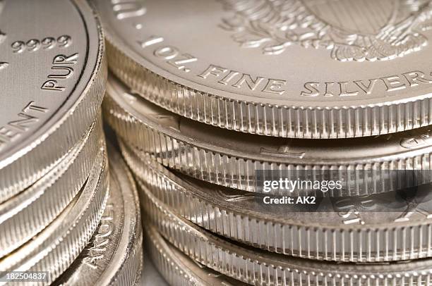 piles of silver coins - silver coloured stock pictures, royalty-free photos & images