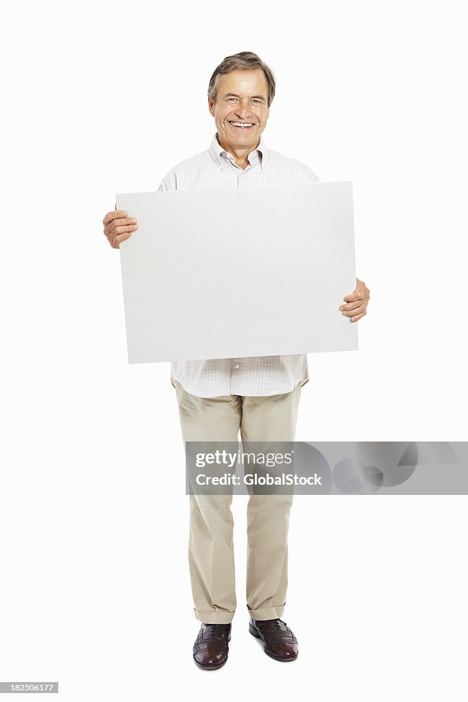 Happy mature man with a blank signboard isolated on white