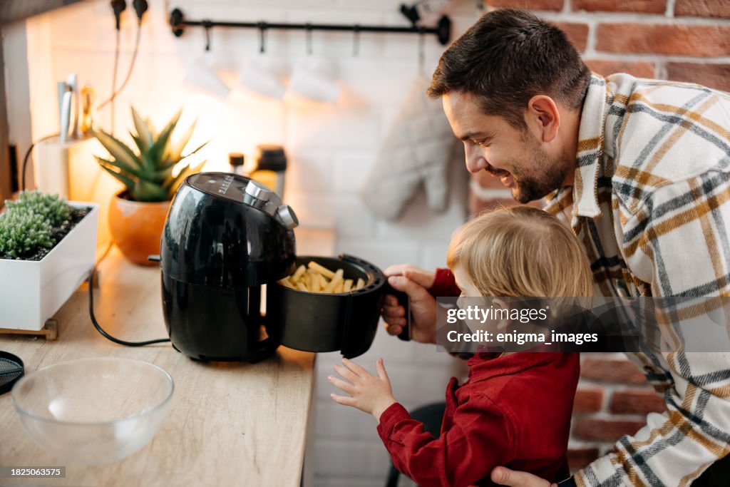 Father and son using air fryer