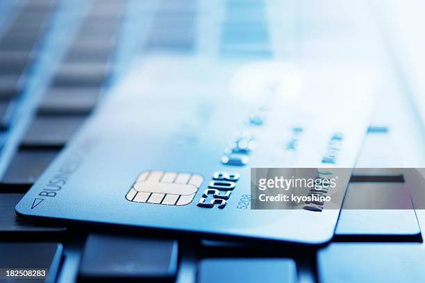 blau getönten bild von kreditkarte auf laptop - credit card stock-fotos und bilder