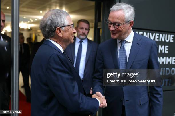 French Finance Minister Bruno Le Maire shakes hands with Microsoft co-founder and Bill & Melinda Gates Foundation Co-Chair, Bill Gates after...