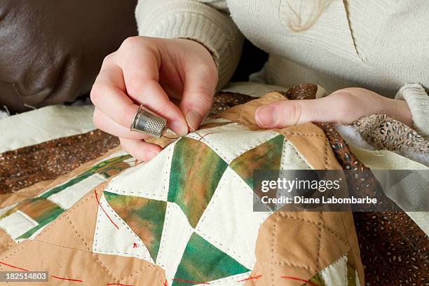 jovem mulher e as mãos com dedal com agulha de costura feito - quilt imagens e fotografias de stock