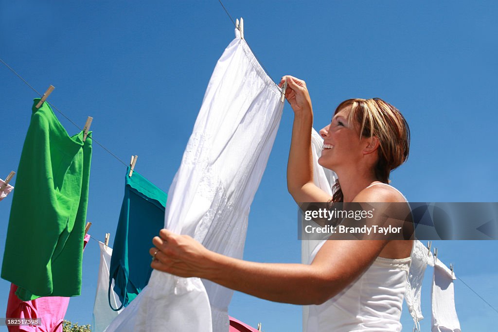 A young woman hanging her laundry to dry outside