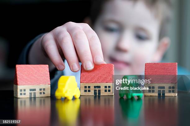 boy with toy houses and cars - playhouse stock pictures, royalty-free photos & images