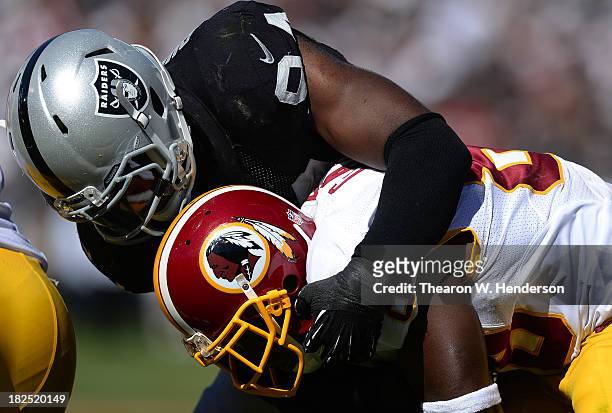 Kevin Burnett of the Oakland Raiders tackles Pierre Garcon of the Washington Redskins during the second quarter at O.co Coliseum on September 29,...