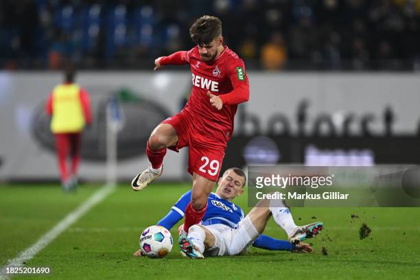 Jan Thielmann of 1.FC Köln battles for possession with Tim Skarke of SV Darmstadt 98 during the Bundesliga match between SV Darmstadt 98 and 1. FC...