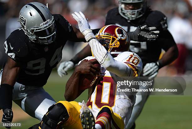 Robert Griffin III of the Washington Redskins gets tackled by Kevin Burnett of the Oakland Raiders during the second quarter at O.co Coliseum on...