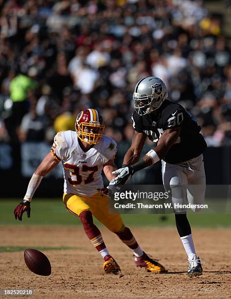 Rod Steater of the Oakland Raiders can't hold on to this pass in front of Reed Doughty of the Washington Redskins during the fourth quarter at O.co...