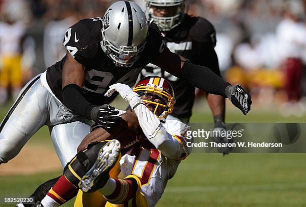 Robert Griffin III of the Washington Redskins gets tackled by Kevin Burnett of the Oakland Raiders during the second quarter at O.co Coliseum on...
