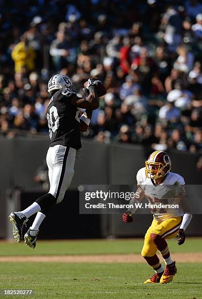 Rod Steater of the Oakland Raiders catches this pass over Reed Doughty of the Washington Redskins during the fourth quarter at O.co Coliseum on...