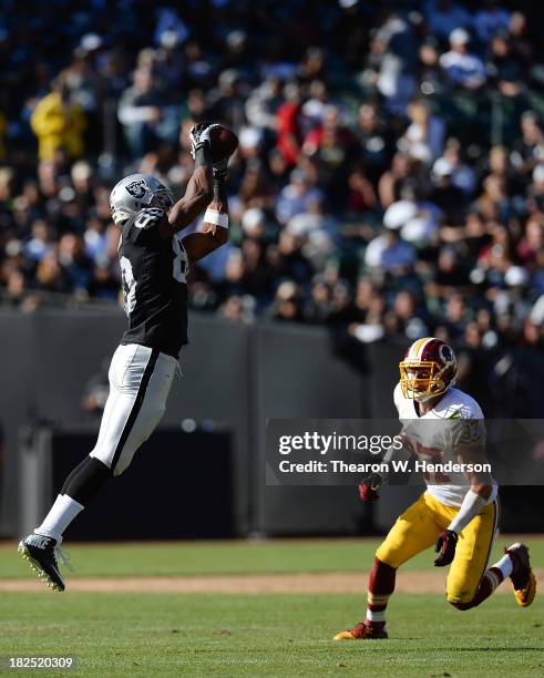 Rod Steater of the Oakland Raiders catches this pass over Reed Doughty of the Washington Redskins during the fourth quarter at O.co Coliseum on...