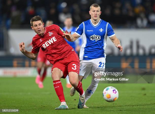 Dominique Heintz of 1.FC Köln passes the ball whilst under pressure from Tim Skarke of SV Darmstadt 98 during the Bundesliga match between SV...