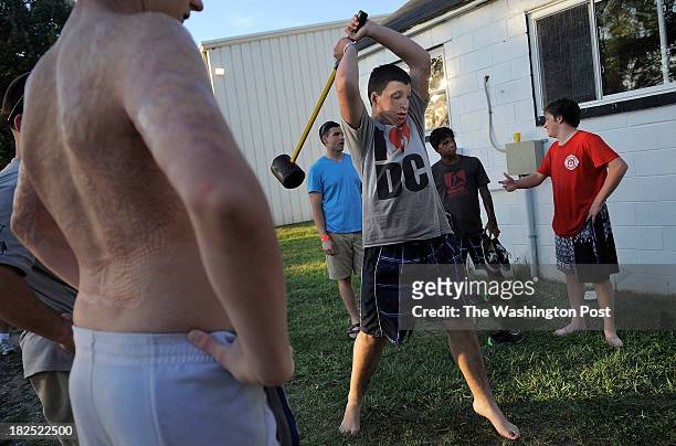 Cody Argo left, looks on as Jordan Hyde center, takes part in a game of strength, known as a "high striker" during International Burn Camp at Wabanna...