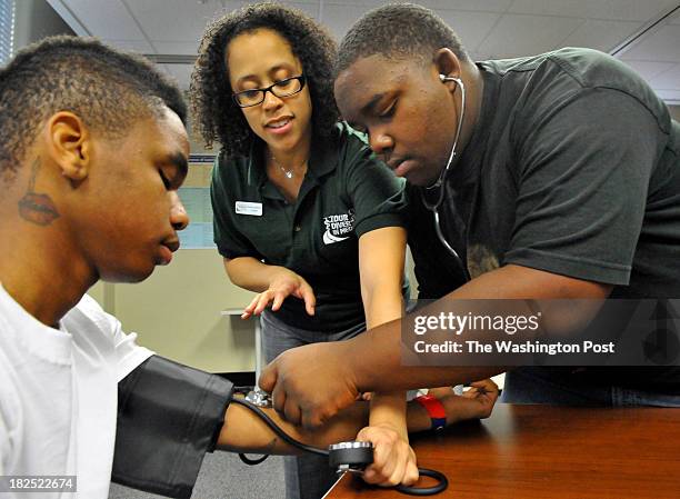 Anacostia high school sophmore Tre Ruffin,16 had his blood pressure checked by Derrick Jones, a sophmore from Ballou high school with help from Dr....